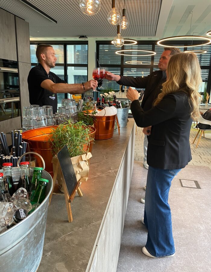 Gäste stoßen mit Cocktails an der mobilen Bar von Pizza Innovazione an