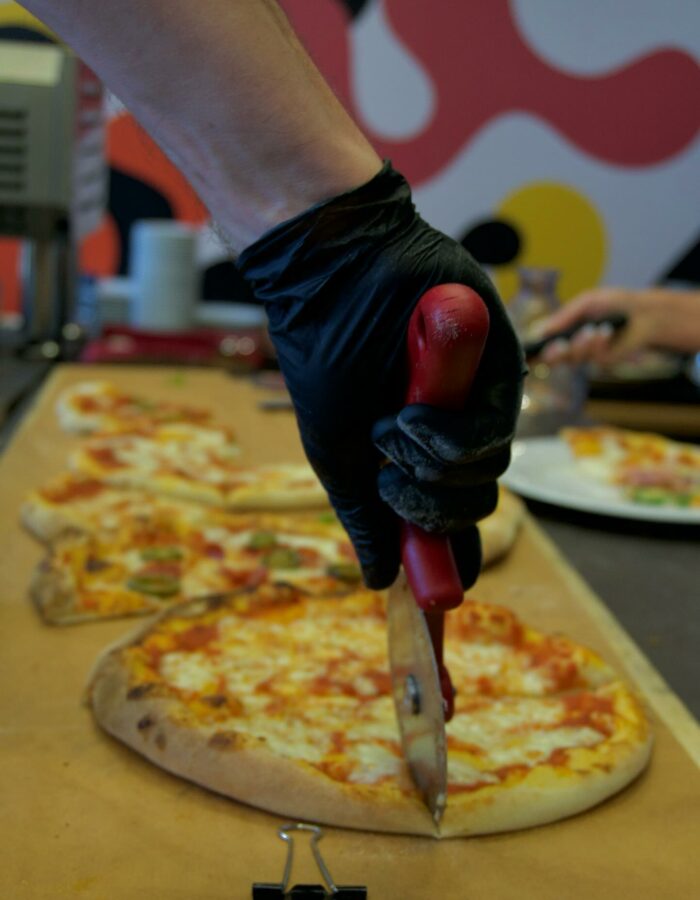 Frische Steinofenpizza wird direkt vor Ort für die Gäste geschnitten
